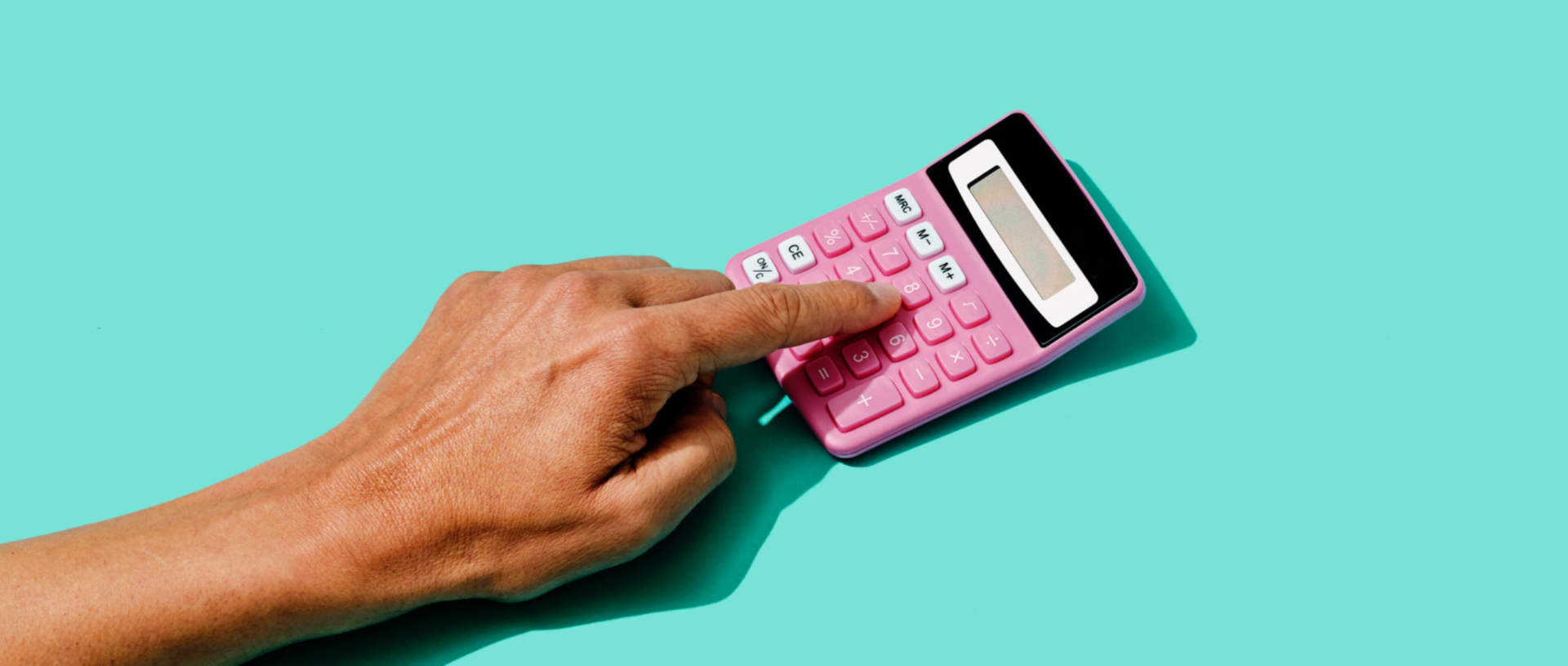 6 Reasons Why a Good Credit Score Matters. A person playing on a pink calculator.