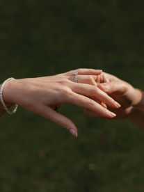 Two hands touching each other with diamond engagement ring