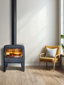 Modern black wood-burning fireplace with lit fire, next to a mustard armchair in a minimalist living room.
