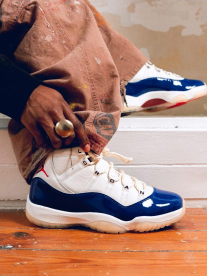 White and blue sneaker on wooden floor matched with brown pants