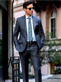 man in grey suit with hands in pocket