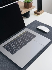 A macbook on a desktop with a magic mouse
